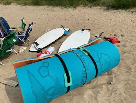 boards and beach gear laying on the beach