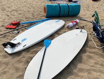 boards and beach gear laying on the beach